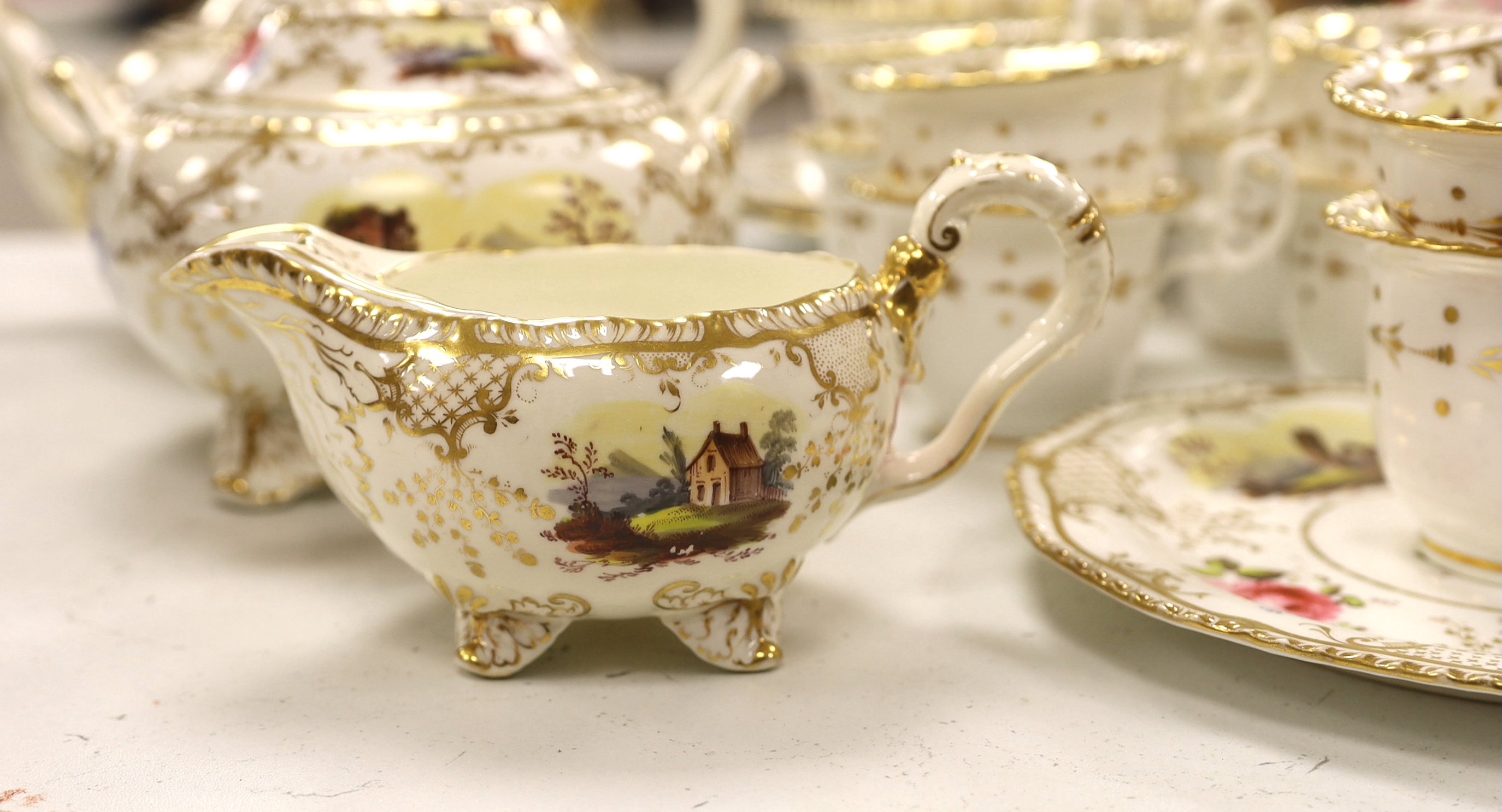 An early 19th century H & R Daniel landscape painted tea and coffee set, including twelve tea cups and saucers, twelve coffee cups, a teapot, a jug and a covered serving bowl, teapot 15cm high